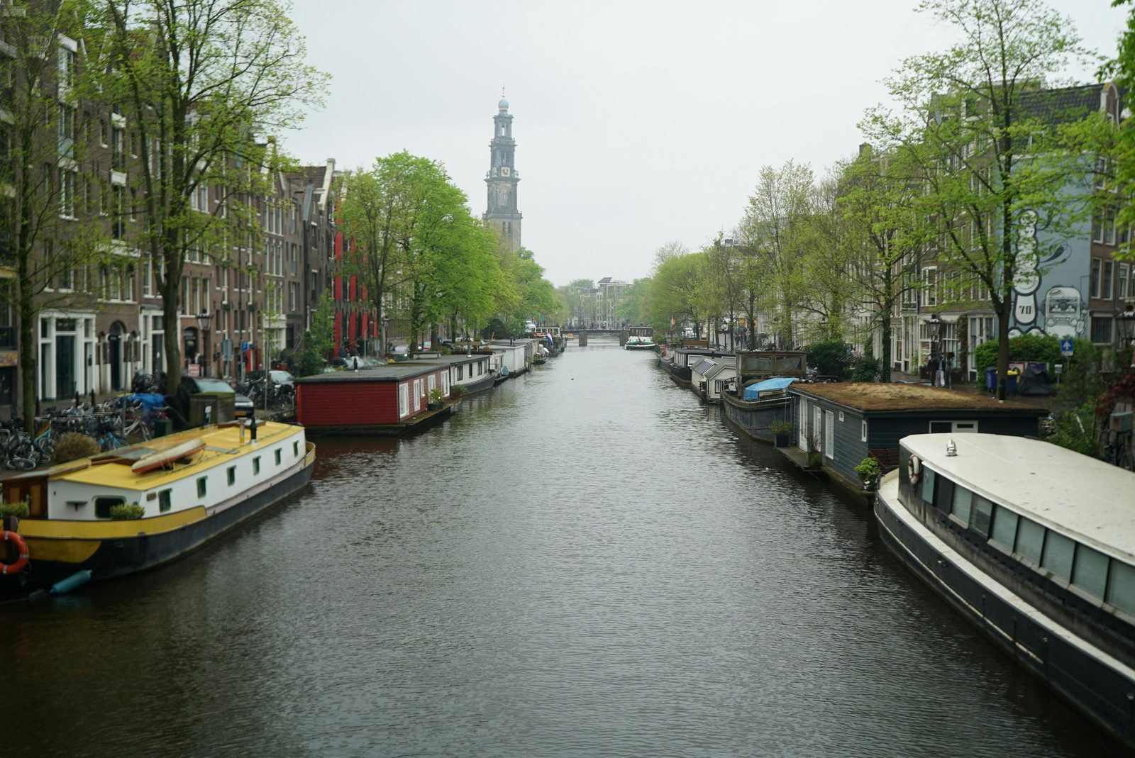 Amsterdamse Prinsengracht met houten woonboten en Westerkerk